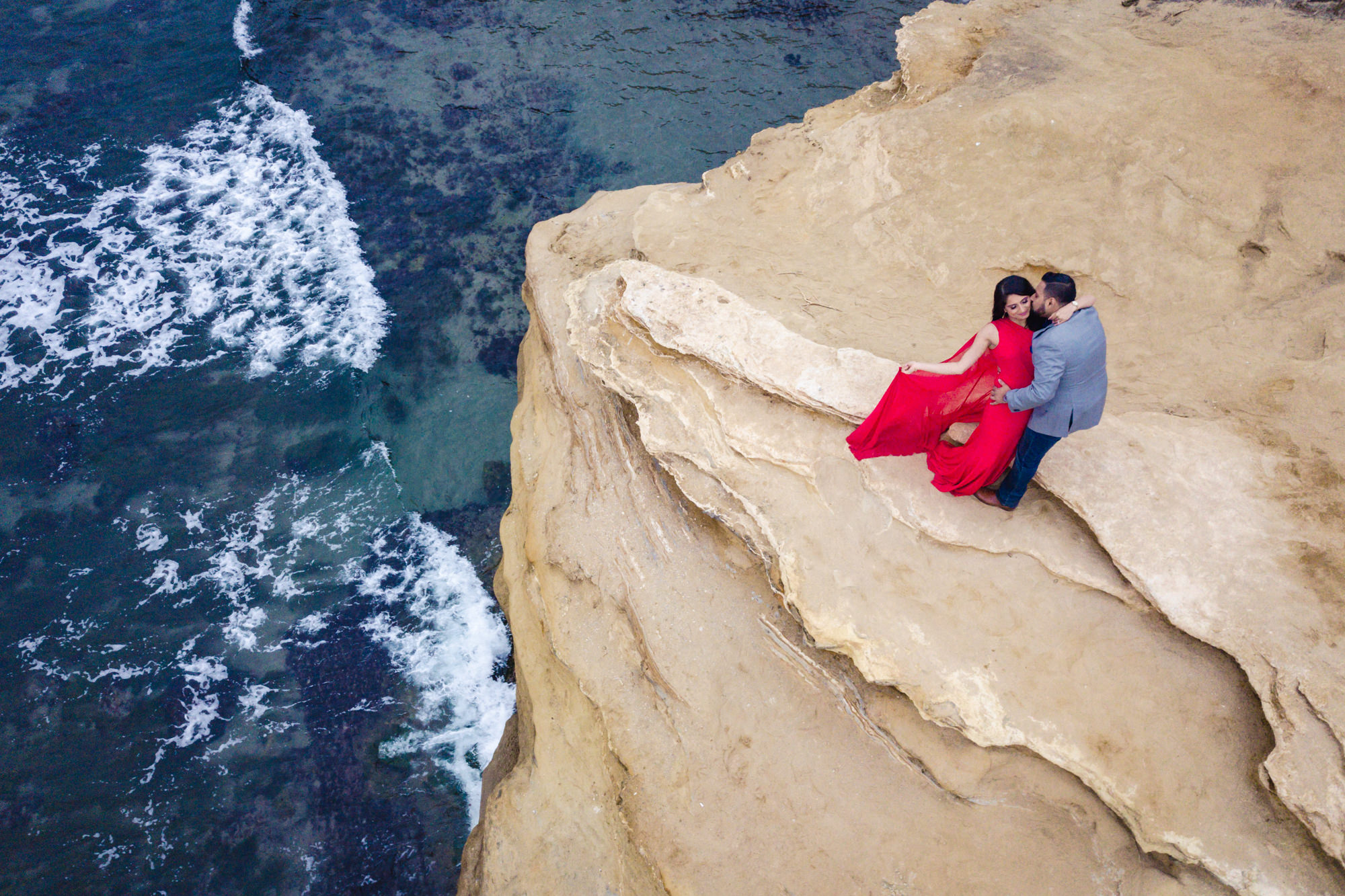 sunset cliffs San Diego engagement photos in red dress and blue waves